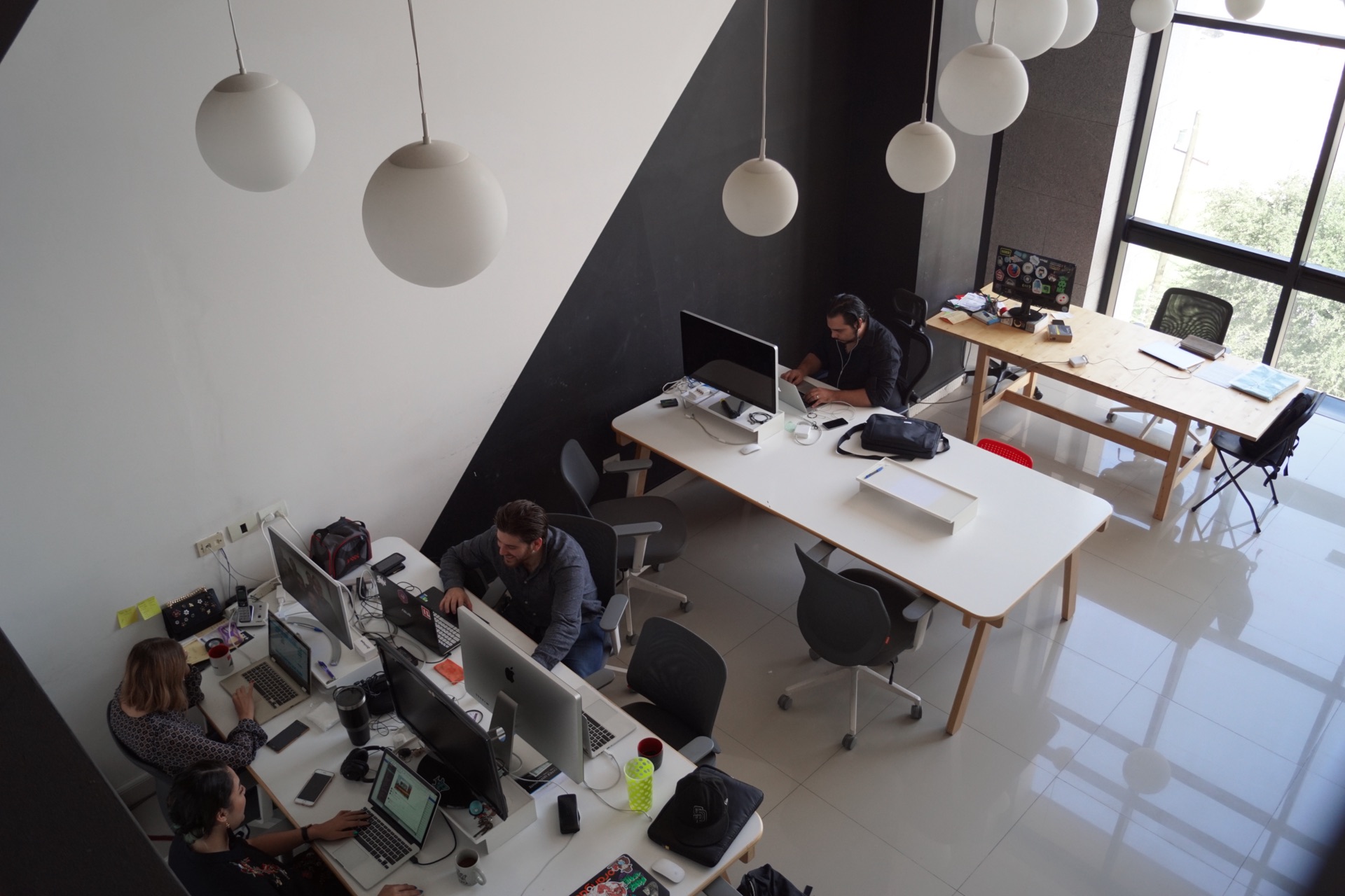 Engineers working at shared desks in the Icalia Labs office in Monterrey, Mexico, seen from above